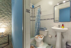 A bathroom with a toilet, sink, and shower area. - Hostal Zanja (Havana)