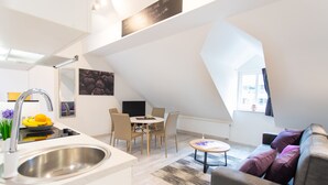A modern kitchen with a sink and a dining area with chairs and a table. - Apartments Beautiful You Are 2 (Zagreb)
