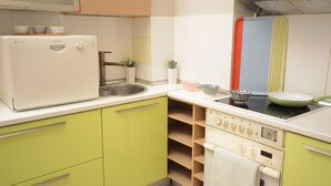 A kitchen with a washing machine, stove, sink, and various kitchenware. - House Loft Foursquare (Thessaloniki)