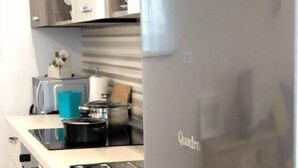 Een moderne keuken met een roestvrijstalen koelkast, een inbouwoven en een aanrecht met een broodrooster en waterkoker.