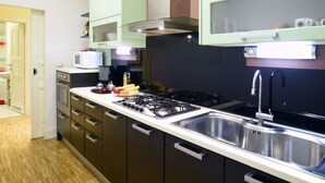 Cozinha moderna com eletrodomésticos de aço inoxidável, micro-ondas e fogão a gás.