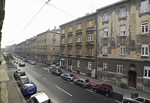 Straßenansicht mit mehreren parkenden Autos und Gebäuden.