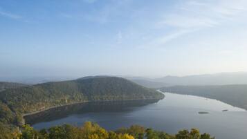 Una vista panorámica de un lago rodeado de colinas boscosas.