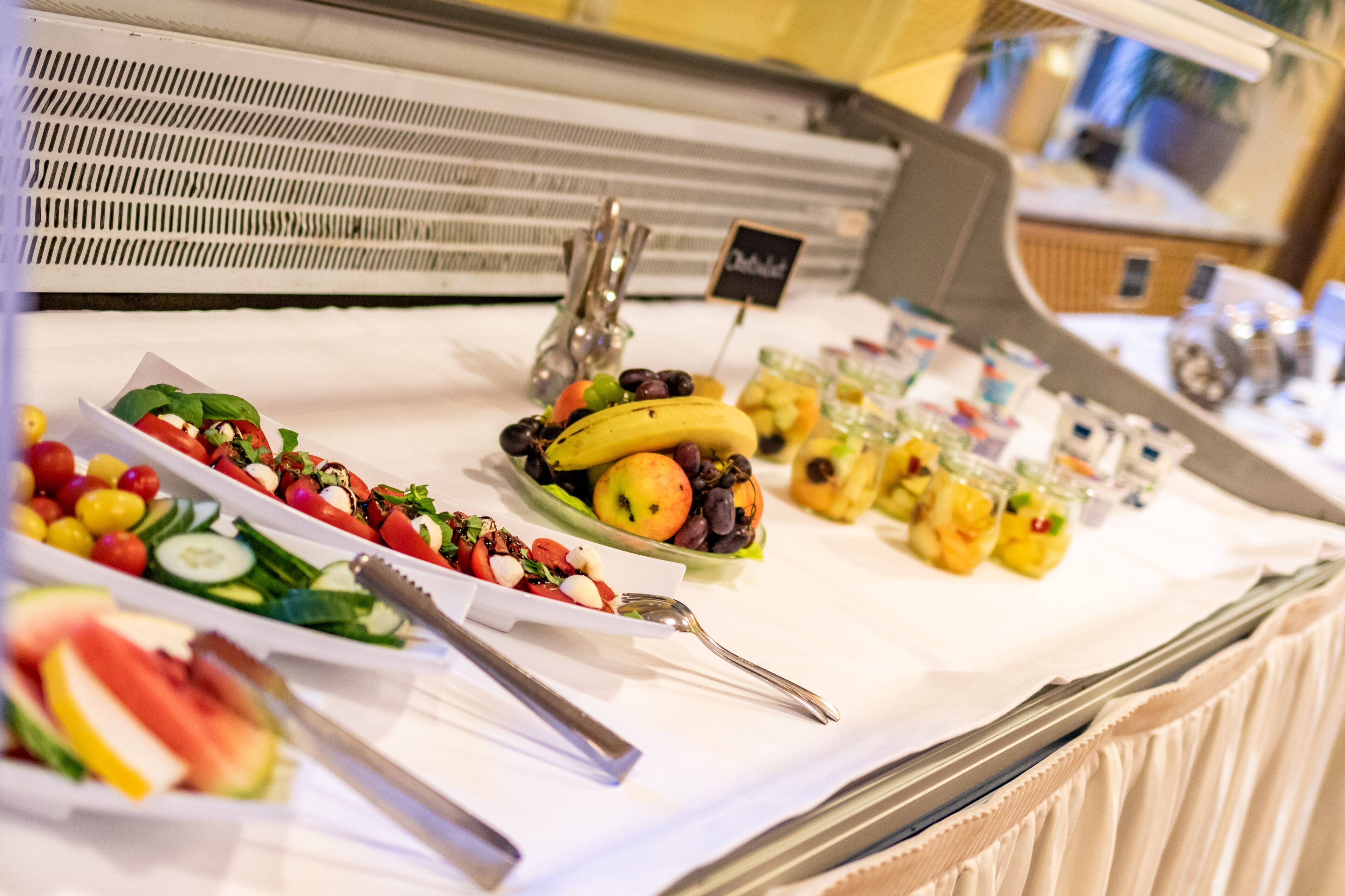 A buffet with various fruits and salads.