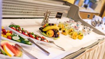 A buffet with various fruits and salads.