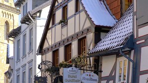 A traditional European building with multiple signs indicating various establishments like a hotel, a restaurant, and a cafe. - Hotel Goldflair am Rathaus (Korbach)