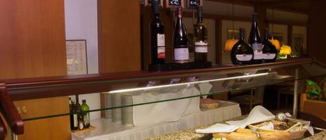 Un mostrador de buffet con diversas opciones de comida y botellas de vino.