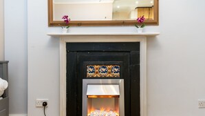 Una chimenea de diseño moderno, con un fachaleta blanca y un revestimiento de azulejos.