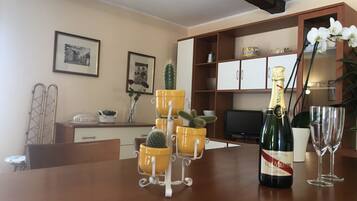 Un tavolo da pranzo con una bottiglia di champagne, due bicchieri da vino e piante in vaso.