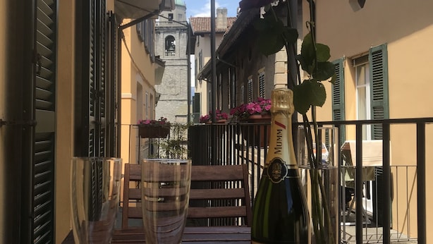 Un balcon avec une table dressée pour deux personnes, agrémentée d’une bouteille de champagne et de deux verres.