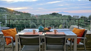 A table with chairs and a view of a mountainous landscape. - Suites in Erbalunga (Brando)