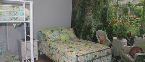 A bedroom with a bunk bed, a single bed, and a chair.