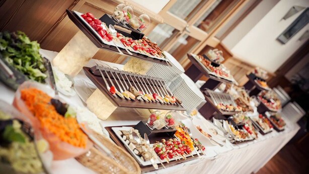 A buffet table with various food items and a grill station. - Landhotel Aschenbrenner (Freudenberg)