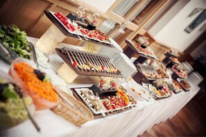A buffet table with various food items and a grill station. - Landhotel Aschenbrenner (Freudenberg)
