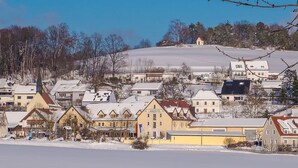 A snow-covered town with a prominent hotel labeled "LANHOTEL" in the foreground. - Landhotel Aschenbrenner (Freudenberg)