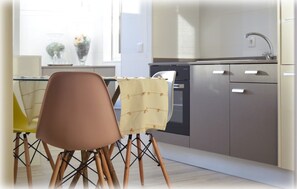 Cozinha moderna com área de refeições, com mesa e cadeiras, lava-louças e armários.
