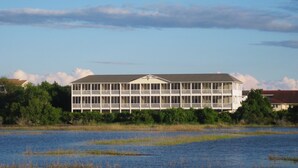 A large, multi-story building with a symmetrical facade, featuring balconies and a central entrance. - The Sunset Inn (Sunset Beach)