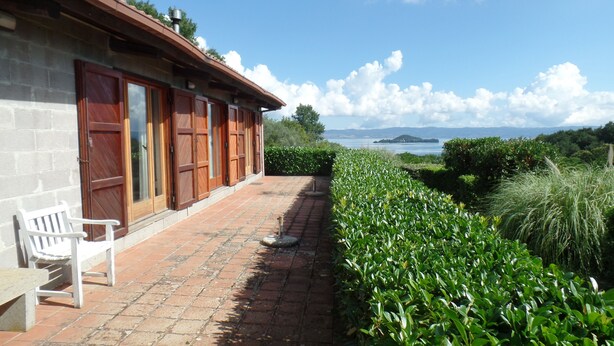 Un edificio con un camino de ladrillo que lleva a un banco y una vista de un lago.