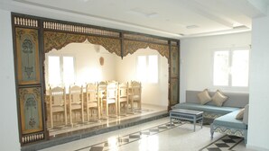 A room with a traditional partition, a sofa, and a dining area with chairs. - House Dar Mamina (Zarzis)