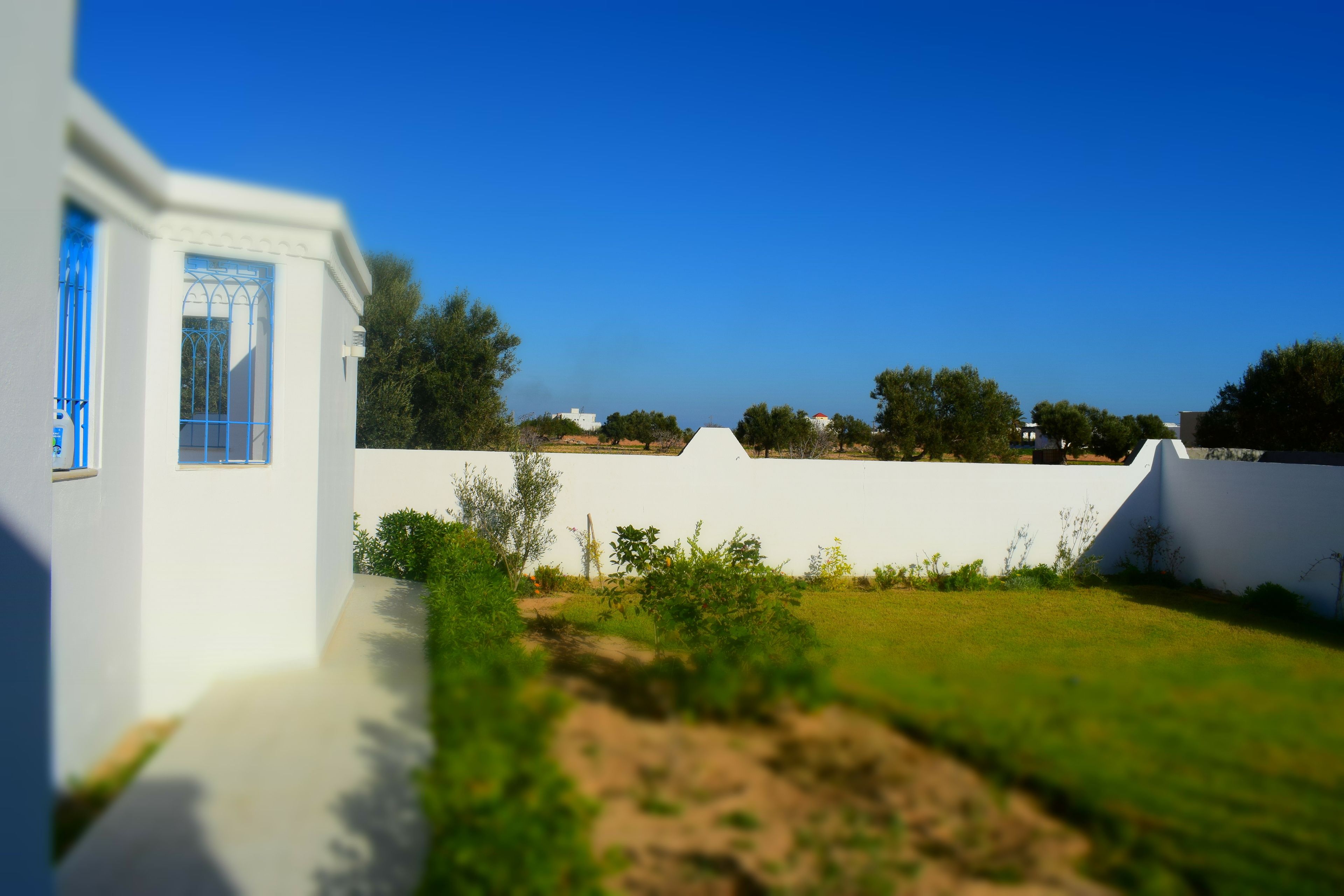 Un bâtiment blanc avec une fenêtre bleue et un mur blanc.
