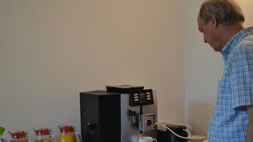 A coffee machine with multiple beverage options and a cup of coffee.