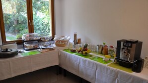 Ein reichhaltiges Frühstücksbuffet mit verschiedenen Speisen und einer Kaffeemaschine.