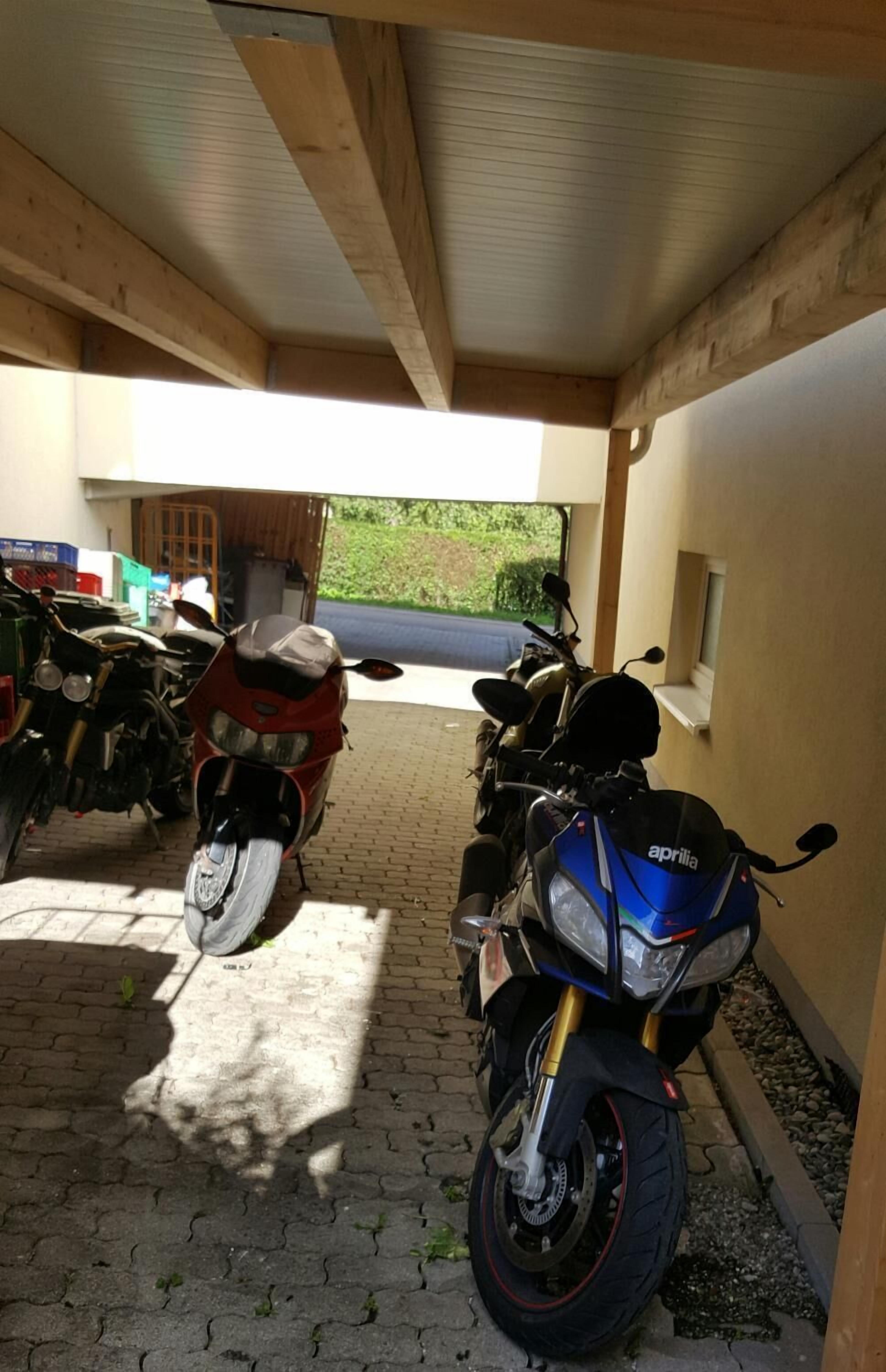 Un espace de stationnement couvert où sont garées des motos.
