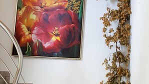 A staircase with a painting of red flowers on the wall above it. - Landgasthof Metzgerei Traube (Heidenheim an der Brenz)