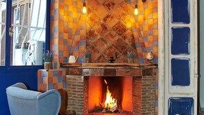 A room with a fireplace, two armchairs, and a checkered wall. - Artisti Bed&Dreams (Naples)