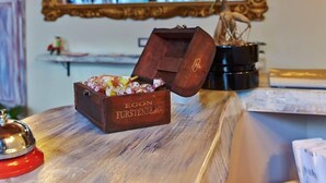 A wooden chest with a plant, a mirror, and a small bell on a wooden surface. - Artisti Bed&Dreams (Naples)