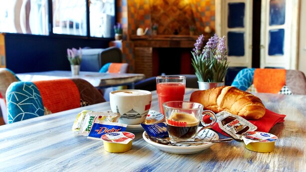 A breakfast table with a croissant, coffee, juice, and yogurt parfaits. - Artisti Bed&Dreams (Naples)