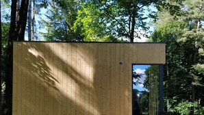 A wooden cabin with a door leading to an interior space, surrounded by trees. - Kaletka (Ilawa)