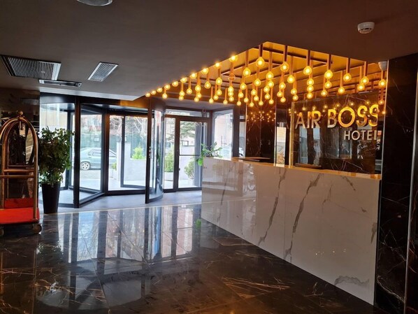 A hotel reception area with a marble floor, a glass door entrance, and a sign reading "AIR BOSS HOTEL". - AIR Boss Istanbul Airport AND Fair Hotel (Istanbul)