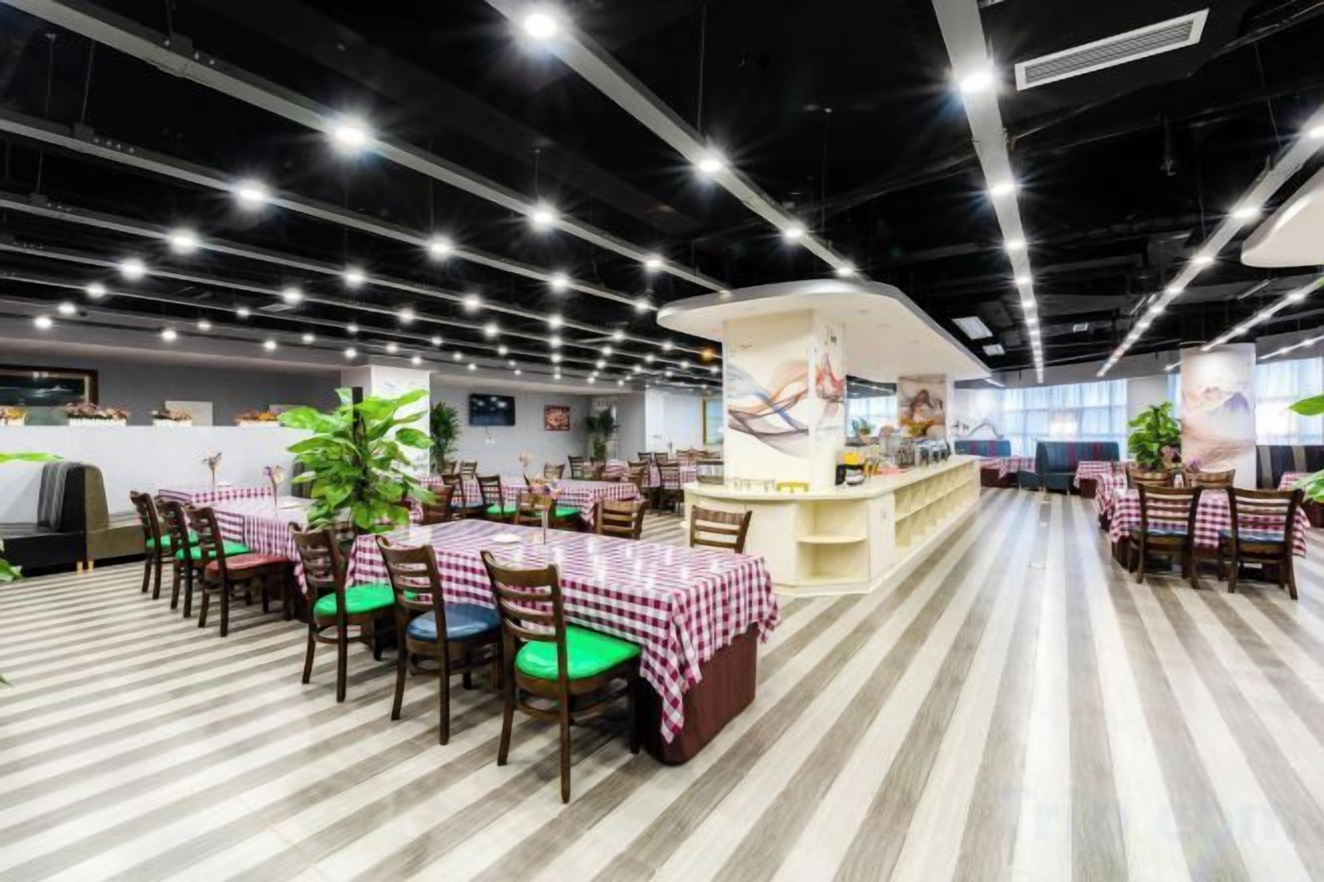 A restaurant with multiple tables and chairs, a counter, and a striped floor.