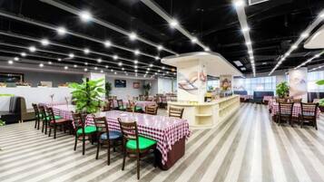 A restaurant with multiple tables and chairs, a counter, and a striped floor.