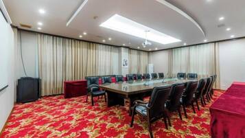 A conference room with a long table, chairs, and a red carpet.