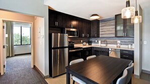 A modern kitchen with dark cabinetry, stainless steel appliances, and pendant lighting. - Residence Inn by Marriott Cincinnati Northeast/Mason (Mason)