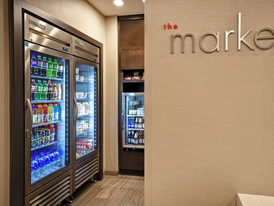 A vending area with refrigerated beverage dispensers and a wall with the text "the market".