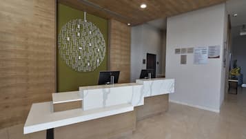 Un comptoir d’accueil au design moderne, un mur en bois et un mur d’accent de couleur verte.