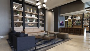 A modern living room with a sofa, coffee table, and shelves with decorative items. - Fairfield Inn & Suites by Marriott Mexicali (Mexicali)