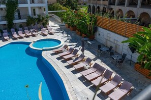 A rooftop pool area with lounge chairs and a small circular pool.