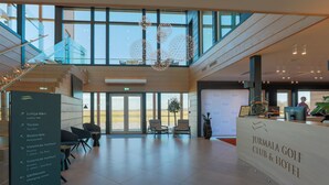 Een modern interieur met een receptiebalie, een zithoek en een trap.