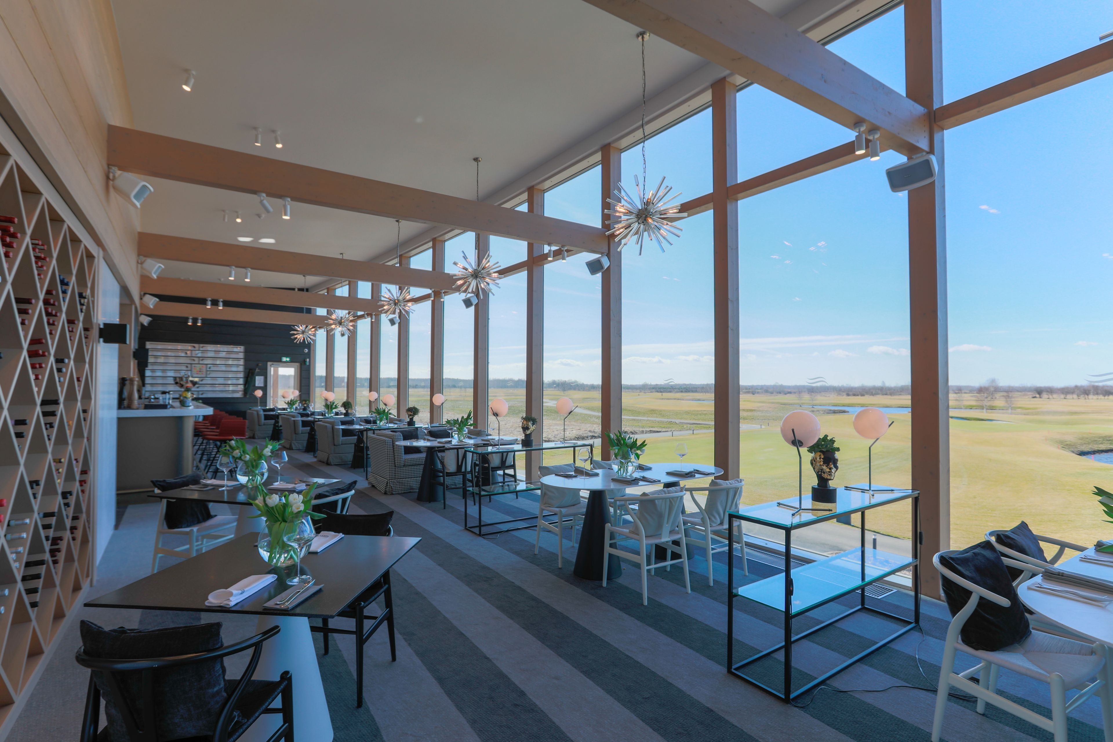 A spacious dining area with large windows offering a view of the countryside.