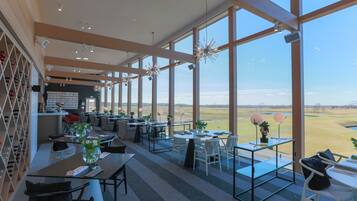 A spacious dining area with large windows offering a view of the countryside.