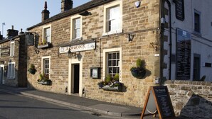A stone building with a sign reading "The Peacock." - The Peacock Inn (Bakewell)