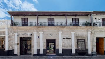 Fachada histórica de un hotel con balcón, columnas y un letrero que indica 'Hotel Santa Rosa'.
