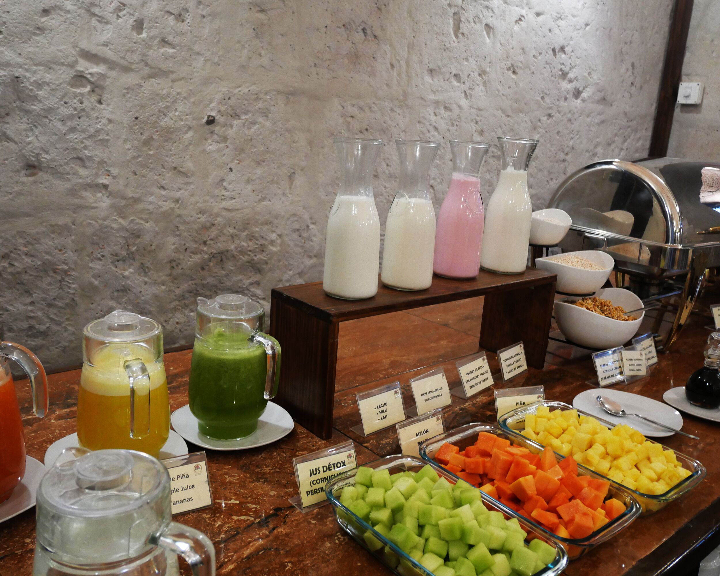 Ein reichhaltiges Buffet mit verschiedenen Speisen und Getränken, darunter Säfte, Milch und Früchte.