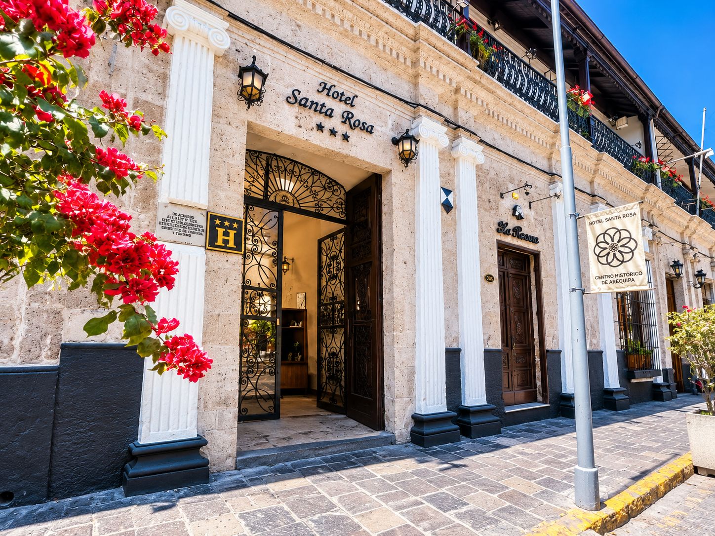 L'hôtel Santa Rosa se distingue par sa façade classique, son entrée imposante et son balcon orné de fleurs.