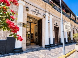 Hotel Santa Rosa con una fachada clásica, una entrada destacada y un balcón con flores.
