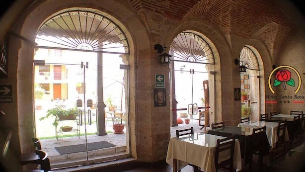 A restaurant with arched doorways, tables, and chairs. - Hotel Santa Rosa (Arequipa)